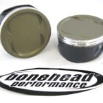 Dry film lubricant coated piston skirts w/ thermal barrier tops.